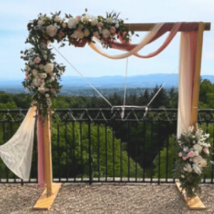 Arche en bois décorée de voilage rose et crème et de fleurs