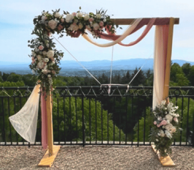 Arche en bois décorée de voilage rose et crème et de fleurs