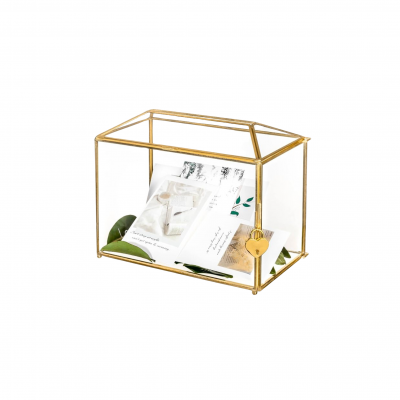 Urne en verre transparent avec des contours dorée, contenant des cartes.